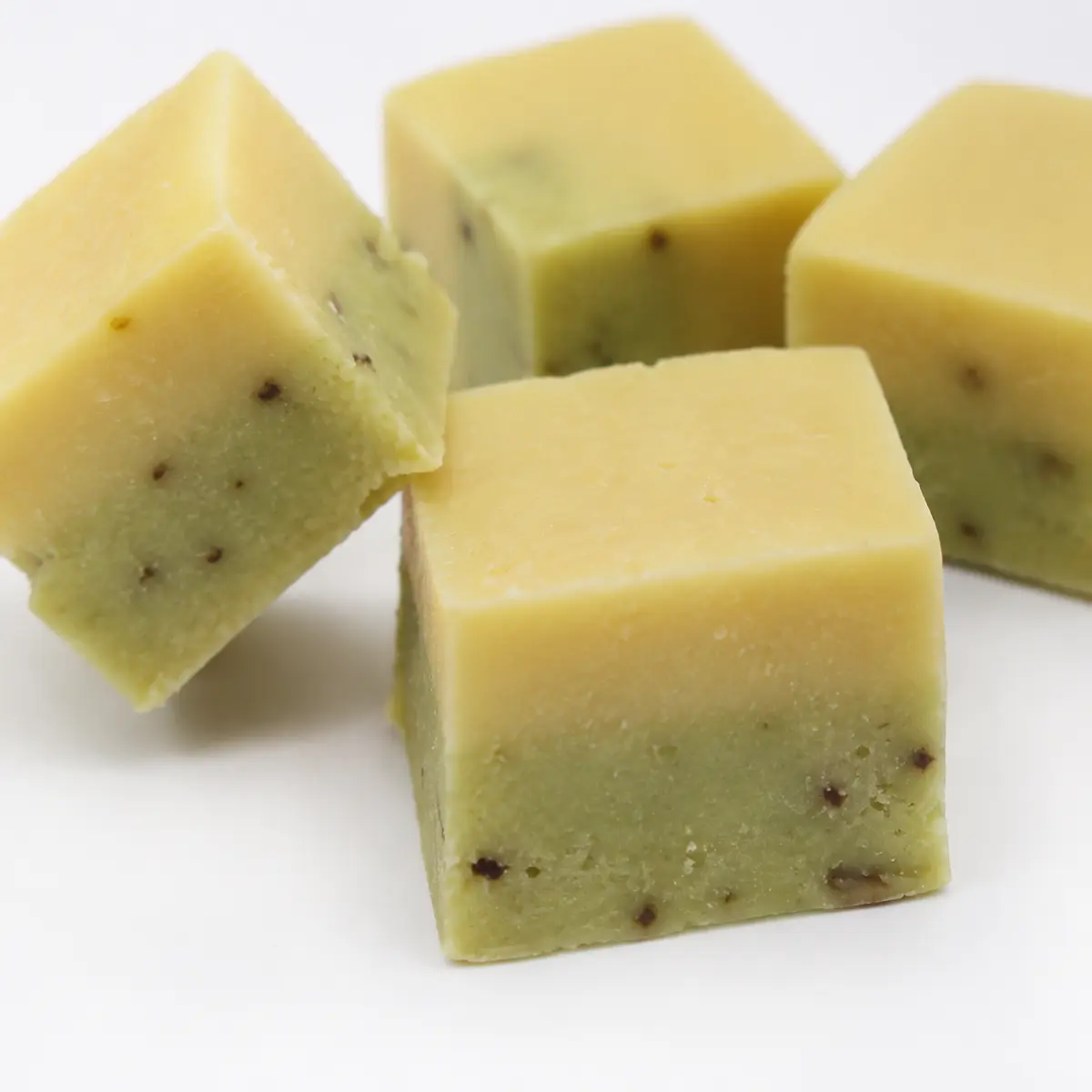 Close-up of two-tone cube treats showing layered cheese and okra texture — view 2