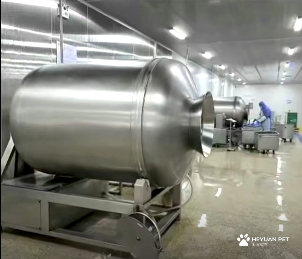 Stainless steel tumbling drum inside HEYUAN PET's production base — used for seasoning and coating of natural pet treats