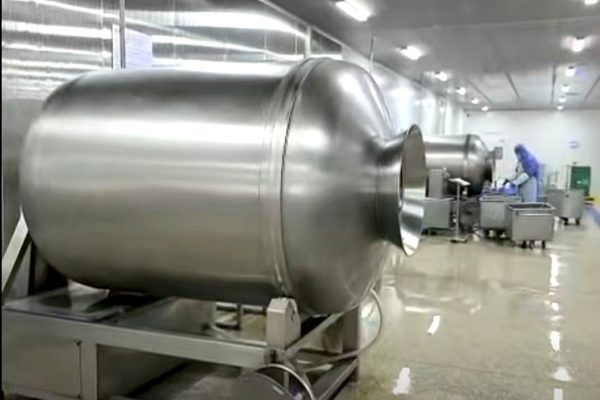 Stainless steel tumbling drum inside HEYUAN PET's production base — used for seasoning and coating of natural pet treats