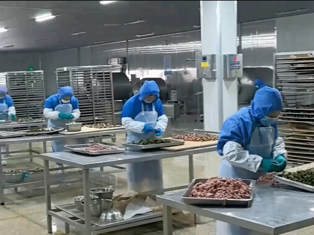 Workers preparing pet treat ingredients in a production workshop at the international-standard pet treat production base in Weifang, China